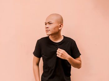 Young man looking away against white background