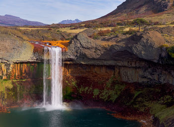 Scenic view of waterfall against mountain