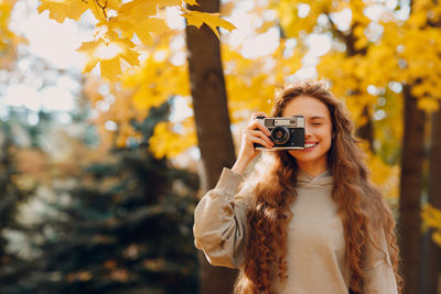 Young woman photographing through mobile phone