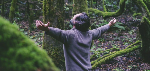 Rear view of man standing in forest