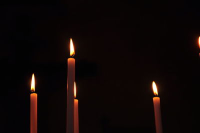 Close-up of illuminated candles against black background
