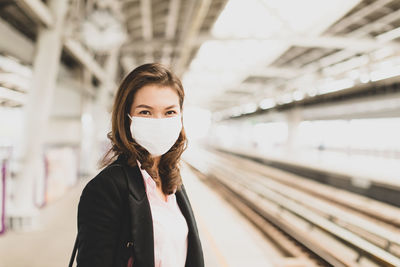 Portrait of woman standing at railroad station