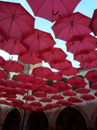 Low angle view of red flags hanging against sky