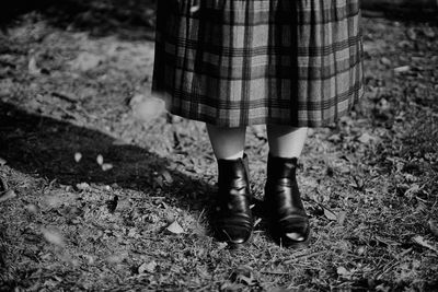 Low section of woman standing on field