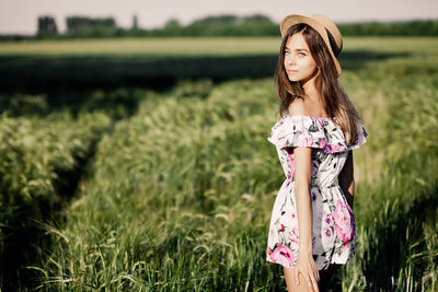 A young girl in a straw hat in a rye field