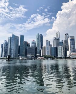 River by modern buildings against sky in city