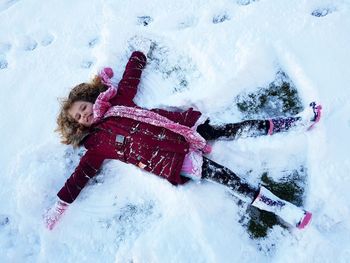 High angle view of girl lying down on snow