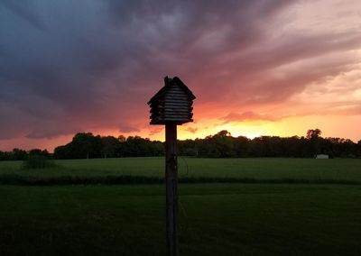 Built structure on field against sky during sunset