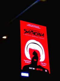 Low angle view of illuminated sign on wall at night