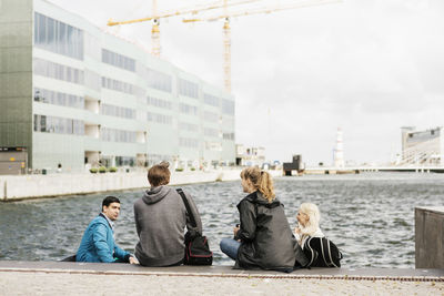 Young friends sitting on steps by river