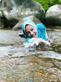 Portrait of smiling woman swimming in water