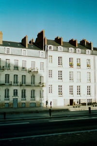 Buildings in city against clear blue sky