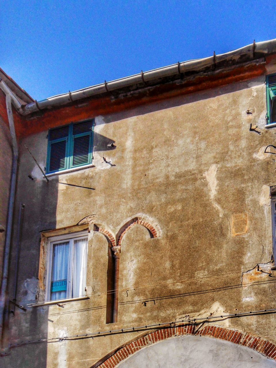 architecture, built structure, building exterior, window, blue, residential structure, low angle view, residential building, clear sky, house, building, old, wall - building feature, wall, door, day, sunlight, outdoors, brick wall, weathered