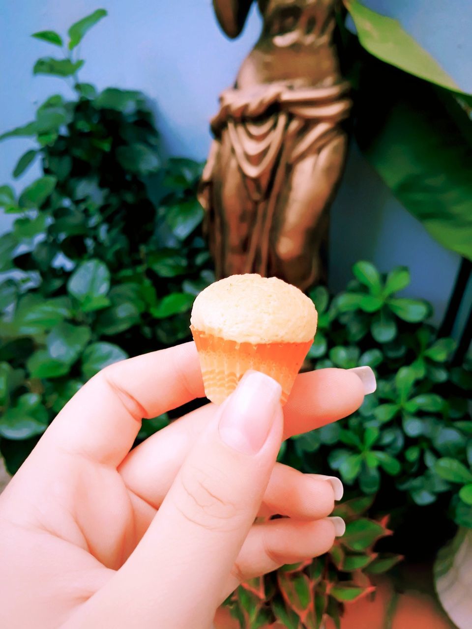 CLOSE-UP OF WOMAN HOLDING ICE CREAM