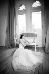 Young woman sitting on bed in bedroom