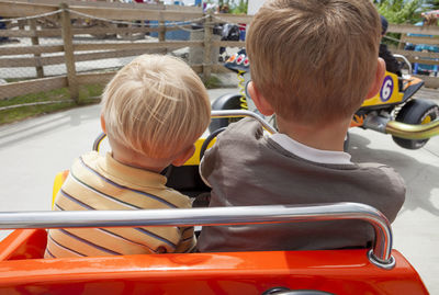 Close-up of siblings sitting in ride