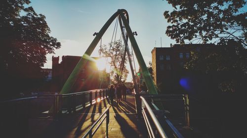 People on bridge at sunset