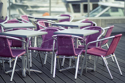Empty chairs and tables at sidewalk cafe