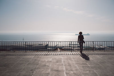 Rear view of woman looking at sea against sky