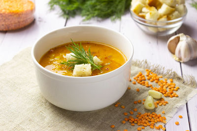 Red lentil soup with ingredients on a light background. traditional turkish or arabic spicy lentil