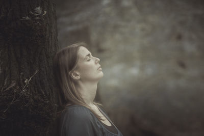 Portrait of young woman looking away outdoors