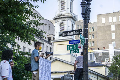 Rear view of people walking on street against buildings