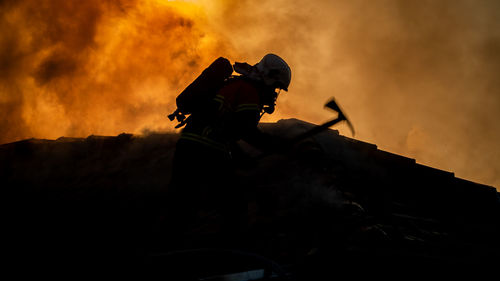 Side view of silhouette firefighter during sunset