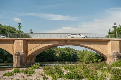 Arch bridge over river against sky