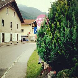 Man on road by houses against mountain