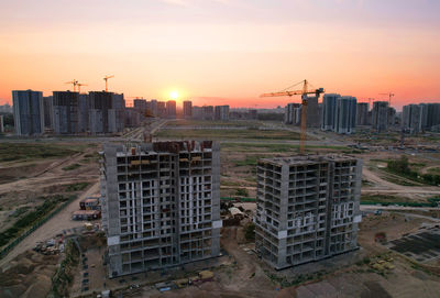 Buildings in city against sky during sunset