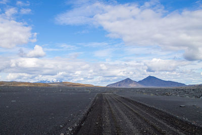 Road leading towards mountain against sky