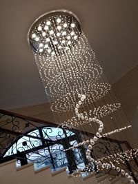 Low angle view of illuminated chandelier hanging on ceiling