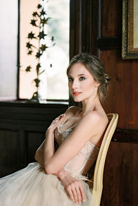 Portrait of young woman sitting at home