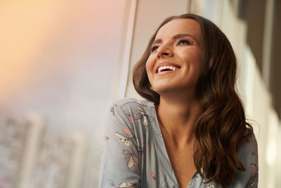 Beautiful young happy woman smiling looks away on the city background. ideal toothy smile 