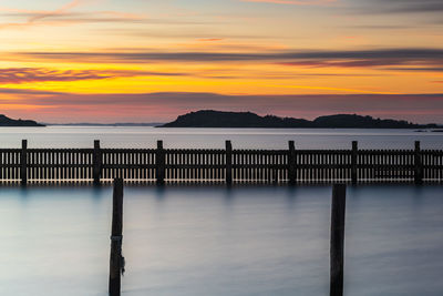 Poles standing in water at empty harbour