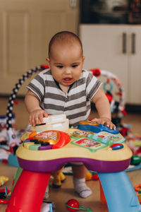 Cute boy sitting on table at home