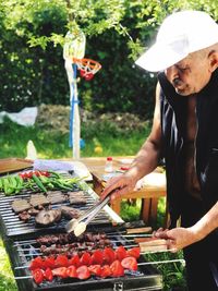 Man preparing food on barbecue grill at market stall