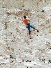 Rear view of man skateboarding on rock