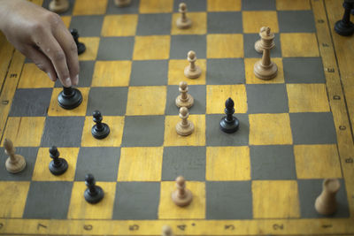 Cropped hand of man playing chess