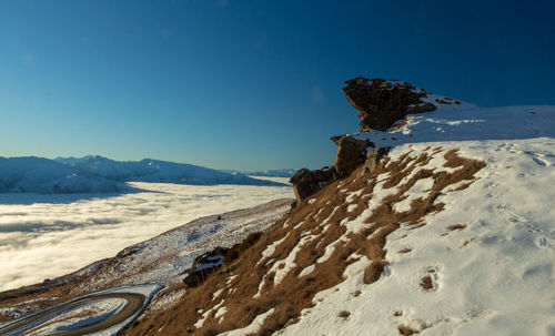 Scenic view of snowcapped mountains against clear blue sky