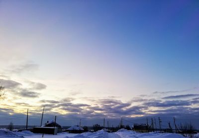 Houses and buildings in city against sky during sunset