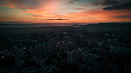 High angle view of modern buildings against sky during sunset