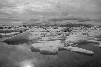 View of frozen sea against cloudy sky