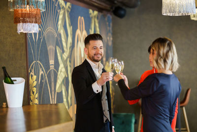 Man and woman toasting drinks at party