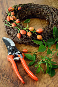 High angle view of autumn decorations with pruning shear on wooden table