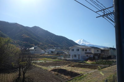 Townscape by mountains against clear sky