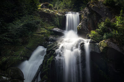 Idyllic waterfall falls into a dark gorge in the black forest