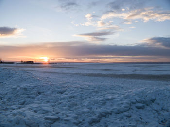 Scenic view of snow covered landscape at sunset