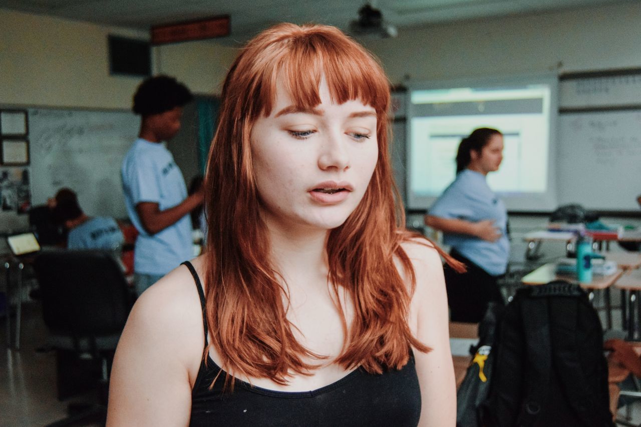 CLOSE-UP OF BEAUTIFUL YOUNG WOMAN STANDING IN CORRIDOR