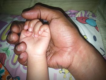Midsection of baby holding hands